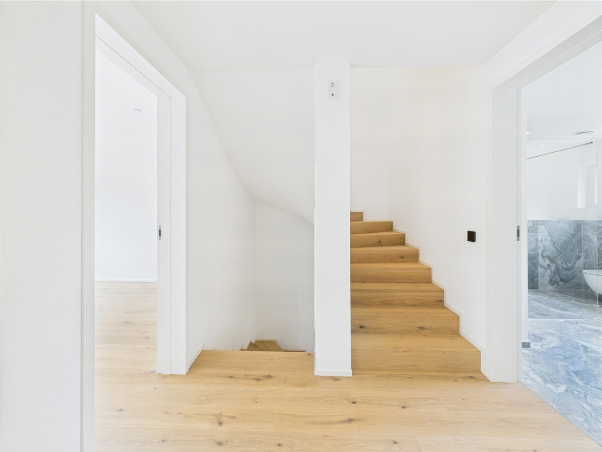 Treppenaufgang und Treppenabgang mit Massivholztreppe in einem Neubauobjekt