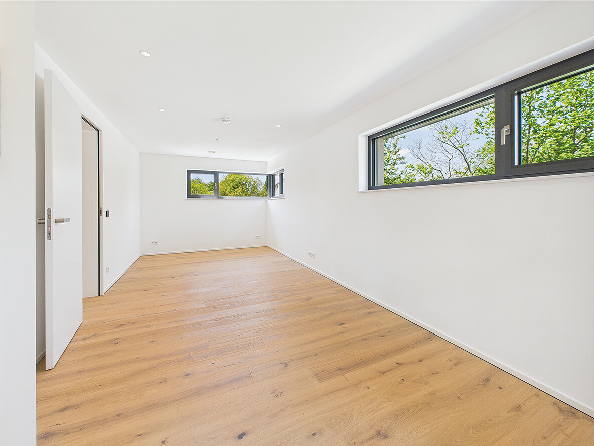 Grosses Zimmer mit Massivholzparkett und modernen Fensterflächen