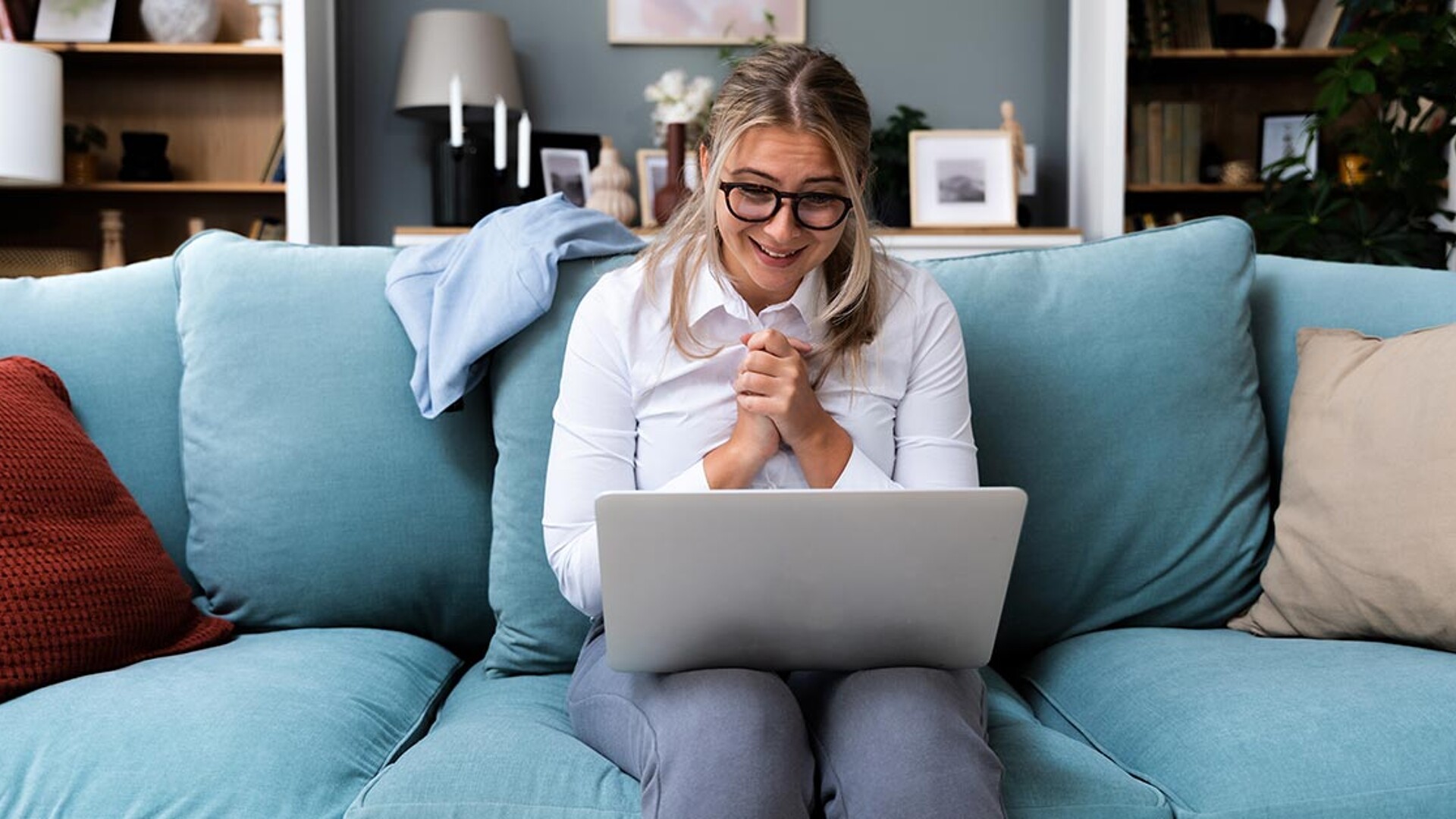 Frau mit Laptop auf Sofa
