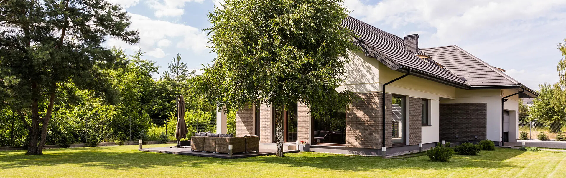 Modernes Haus mit großen Fenstern, Innenhof, Rasen, Bäumen