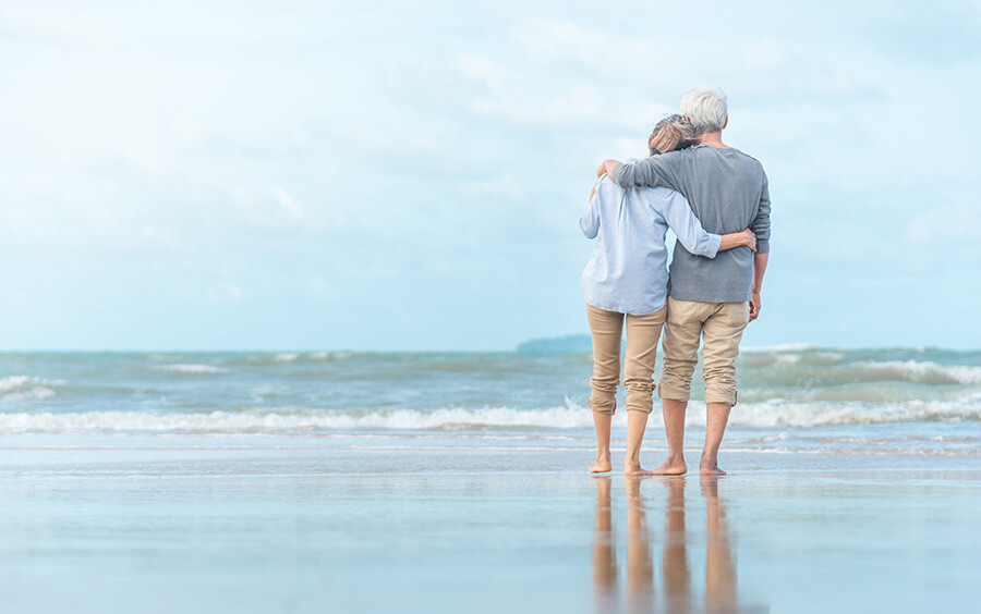 Seniorenpaar spaziert am Strand