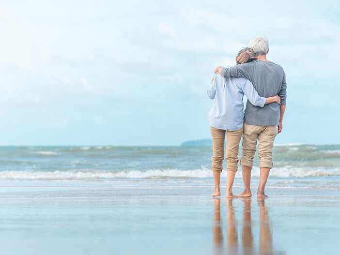 Seniorenpaar spaziert am Strand