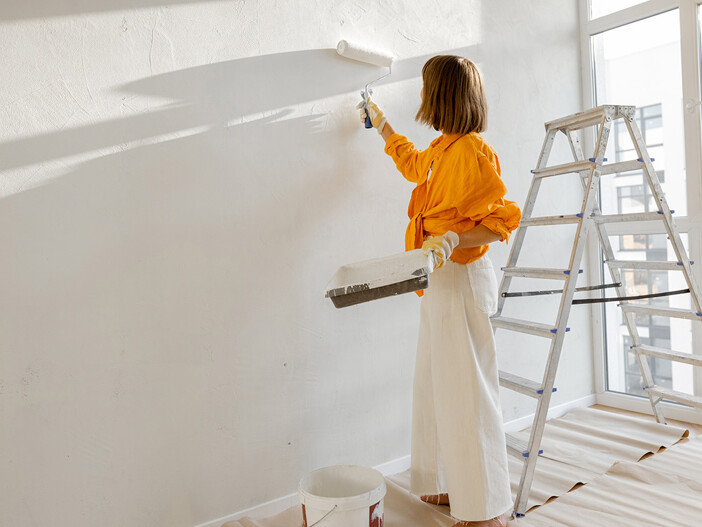 Frau streicht Wand