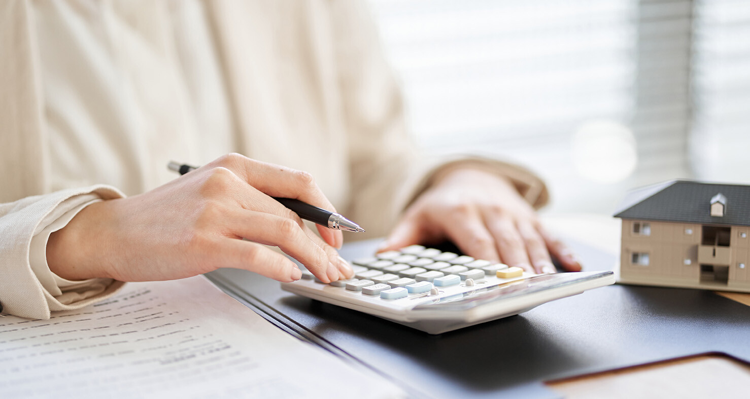 Frau tippt auf Taschenrechner