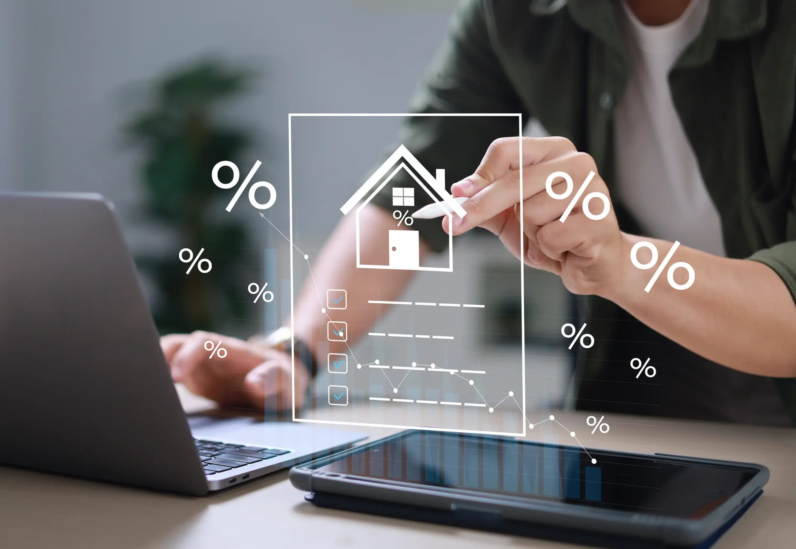 Laptop mit virtuellen Haus- und Prozentzeichen, Thema Immobilien.