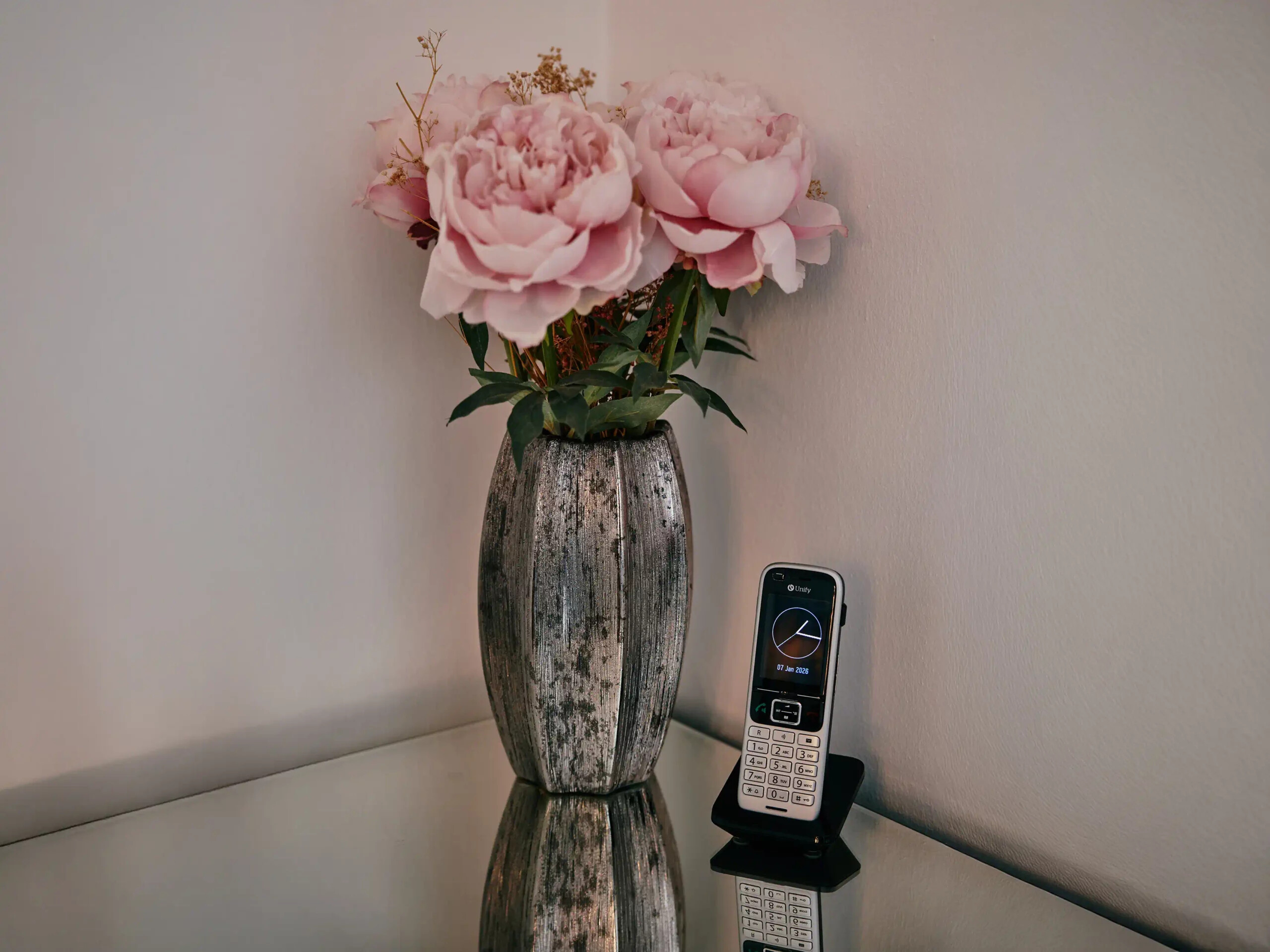 Blumenstrauß neben Telefon