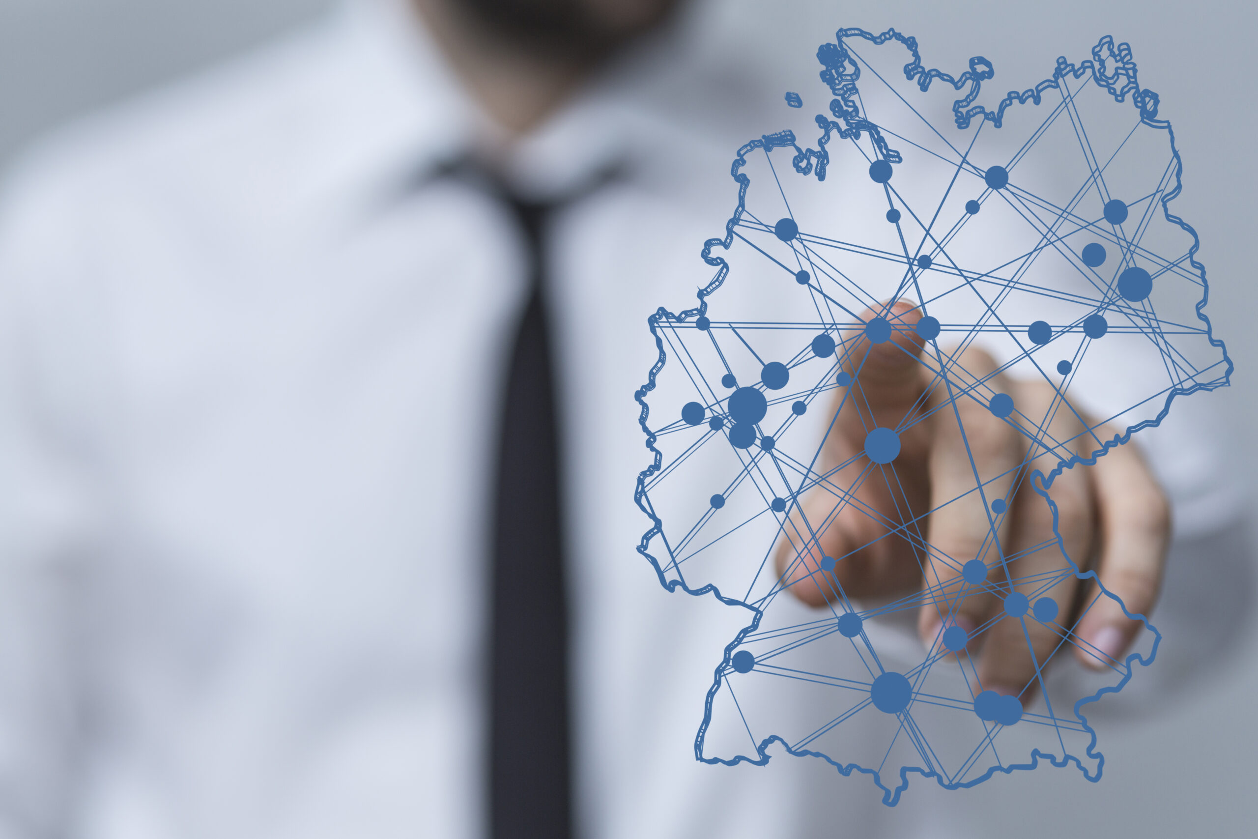 Hand tippt auf digitale Deutschlandkarte mit Netzwerklinien.
