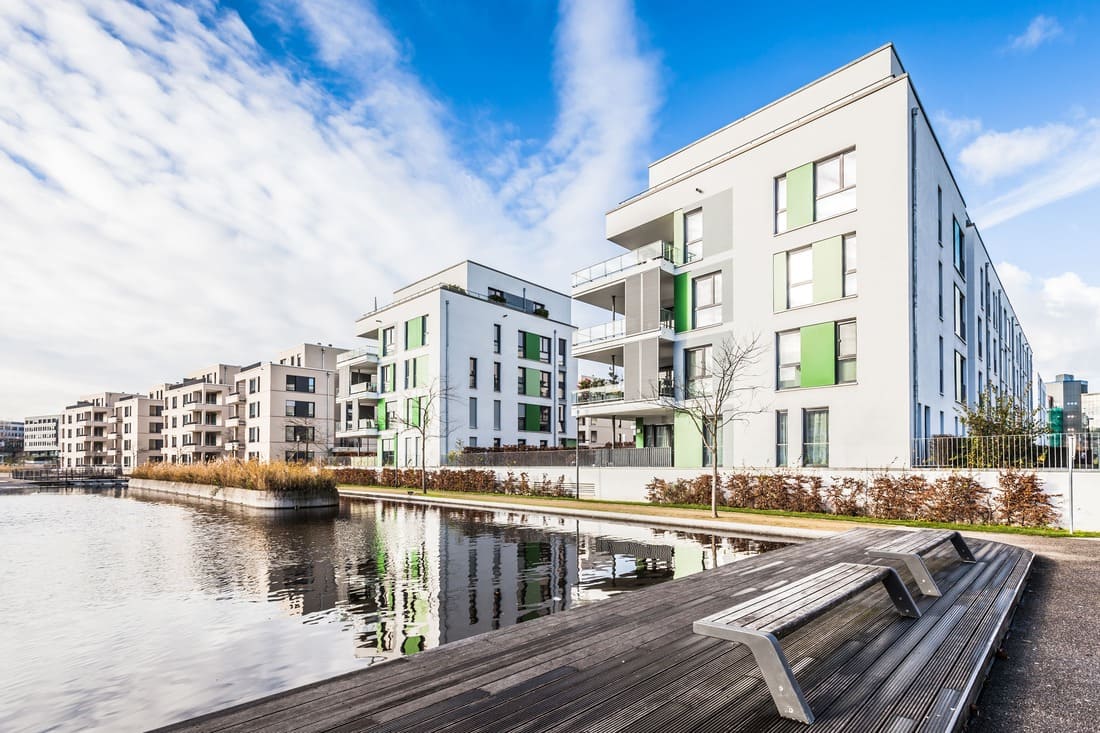 Eine Reihe von Mehrfamilienhäusern an einem Fluss