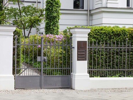 Zaun einer Stadtvilla als Symbol für den diskreten Verkauf