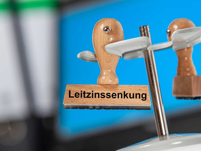 Symbolbild Zinsanpassung durch die EZB: Stempel mit Aufschrift 'Leitzinssenkung'