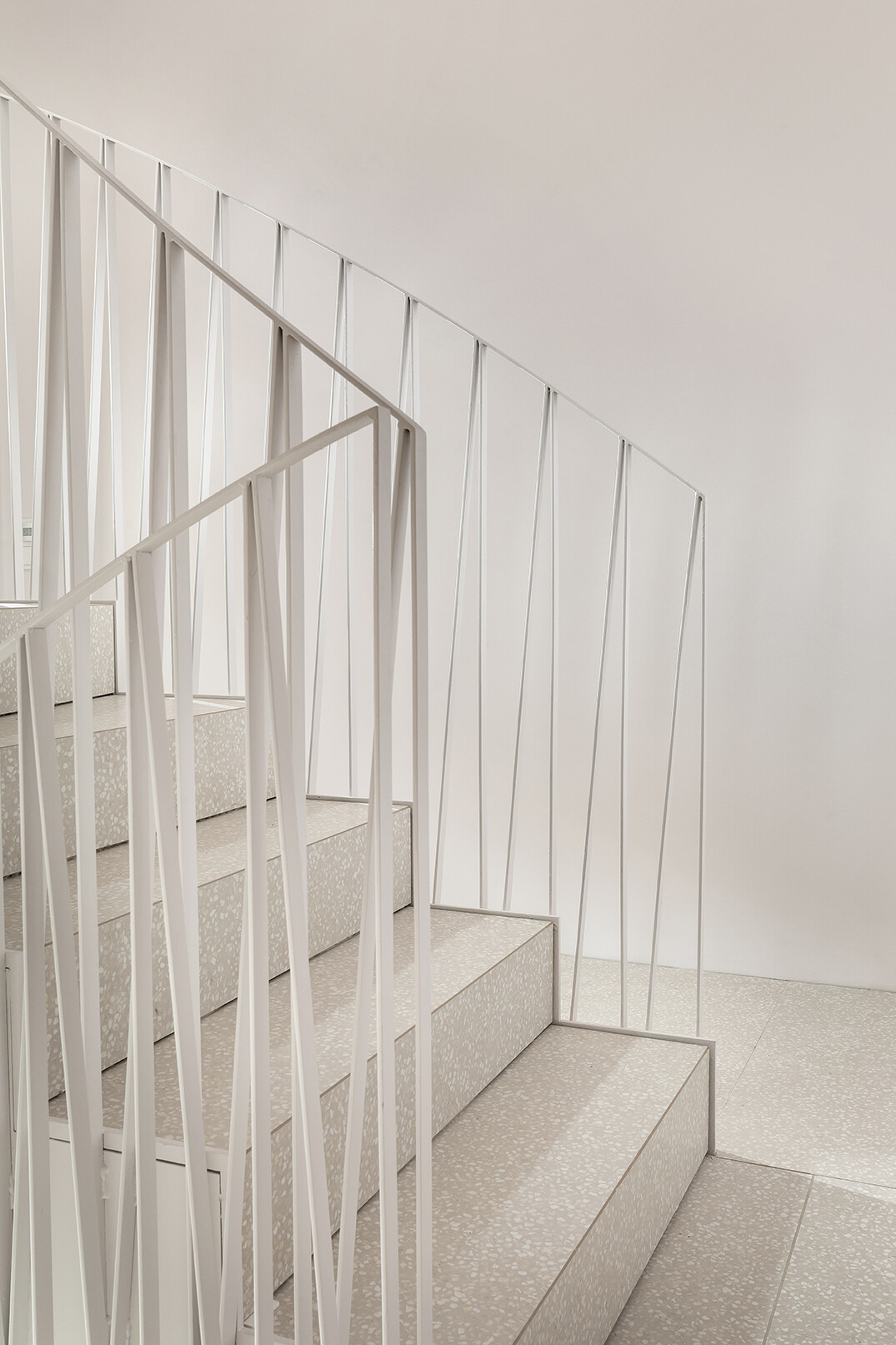 Detailaufnahme Treppenhaus mit Terrazzoboden und skulpturalen Geländer