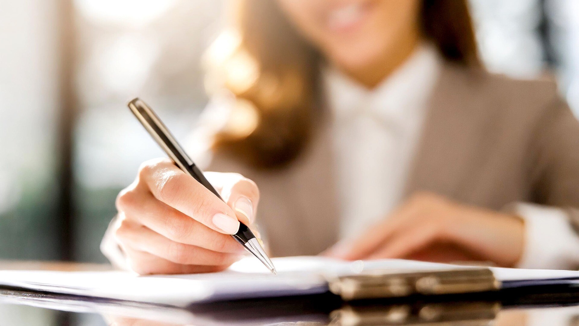 Eine Frau setzt ihre Unterschrift.