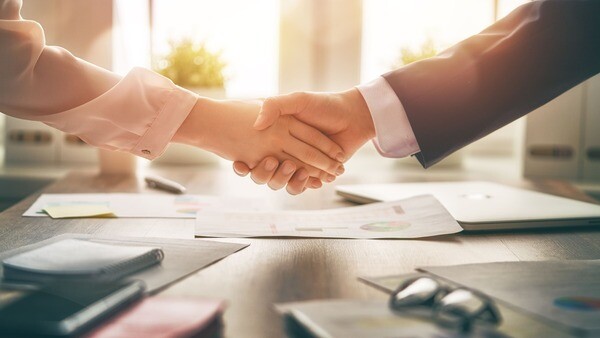 Zwei Menschen reichen sich die Hände.