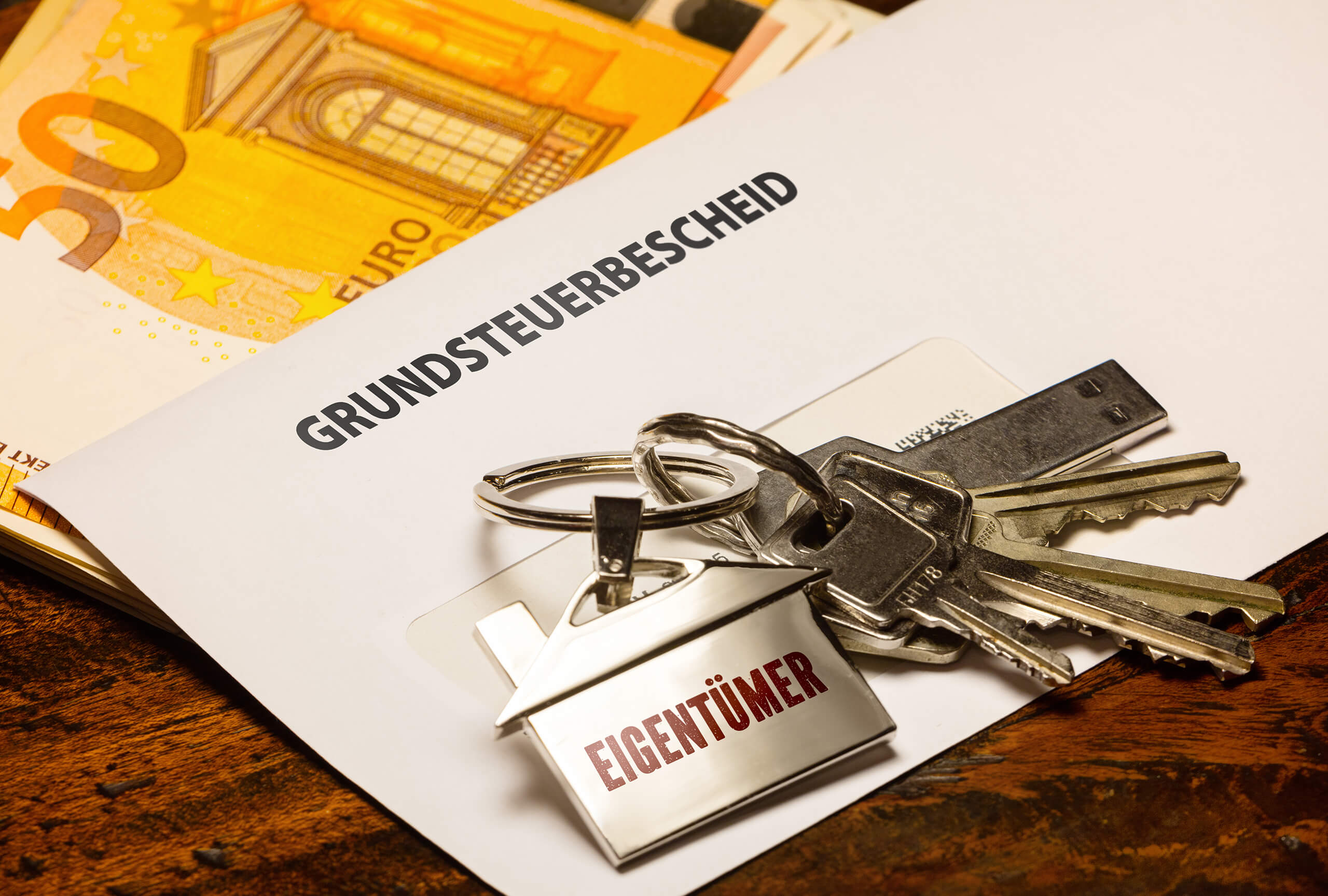 Hausschlüssel liegt auf einem Brief mit Aufschrift 'Grundsteuerbescheid'