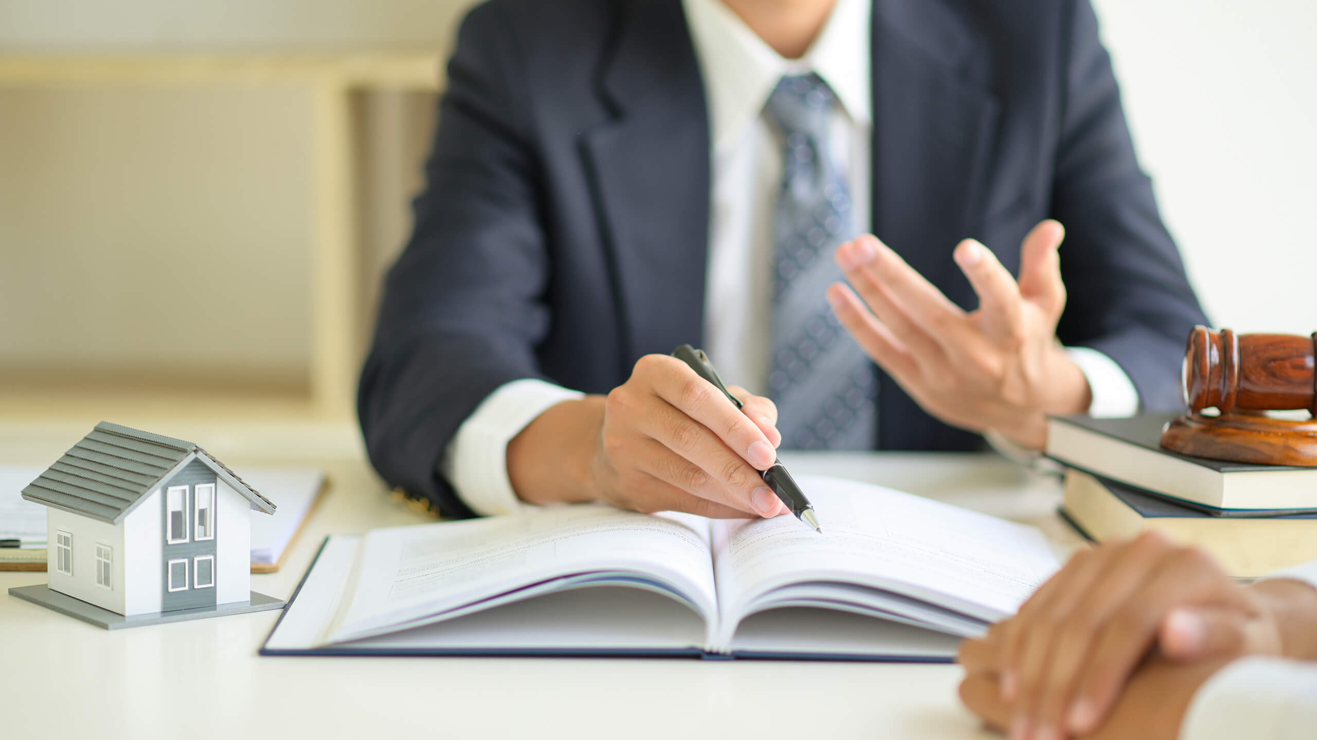 Modellhaus, Richterhammer und Notar: Symbol für Maklerprovision