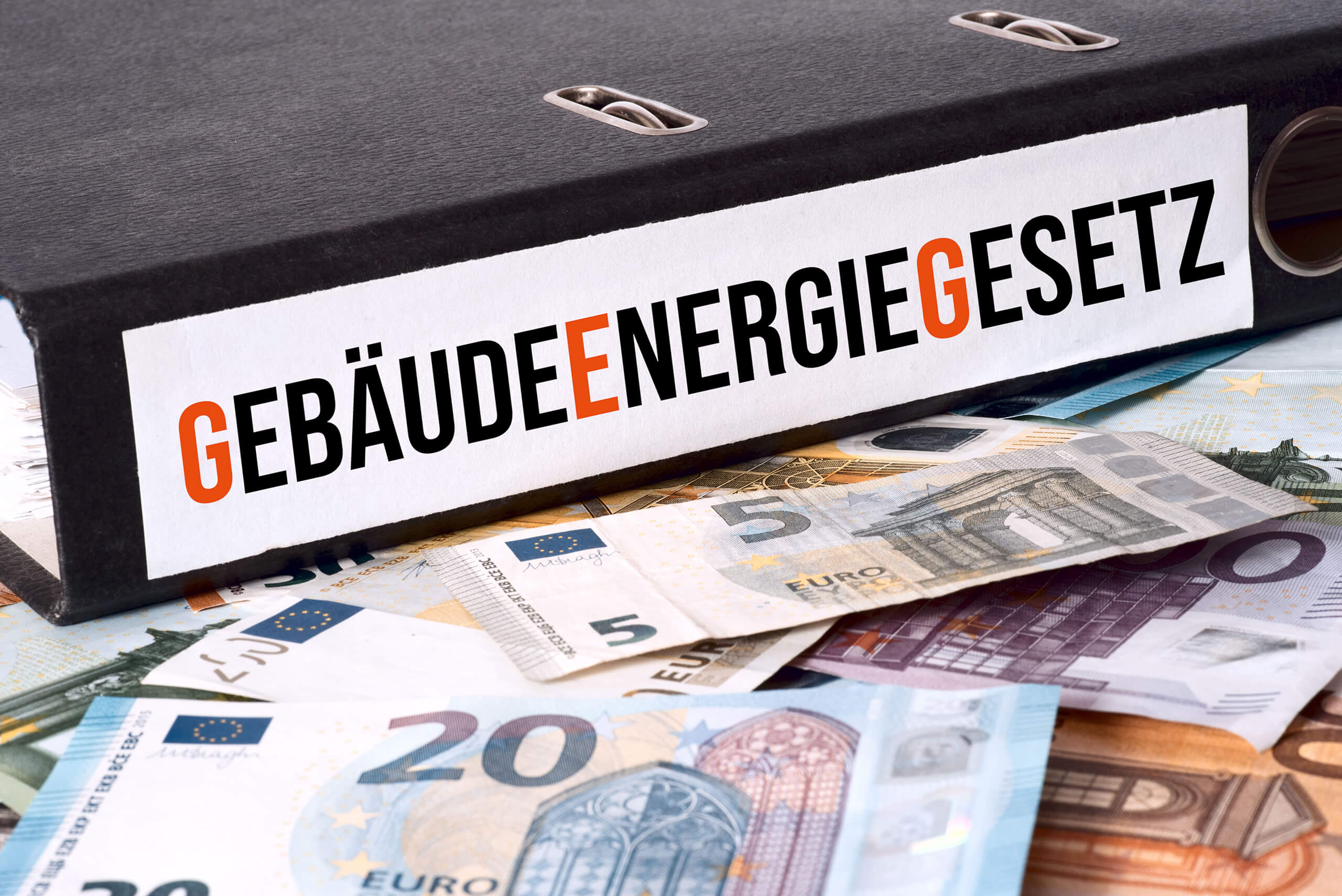 Ordner "Gebäudeenergiegesetz" liegt auf Euroscheinen.