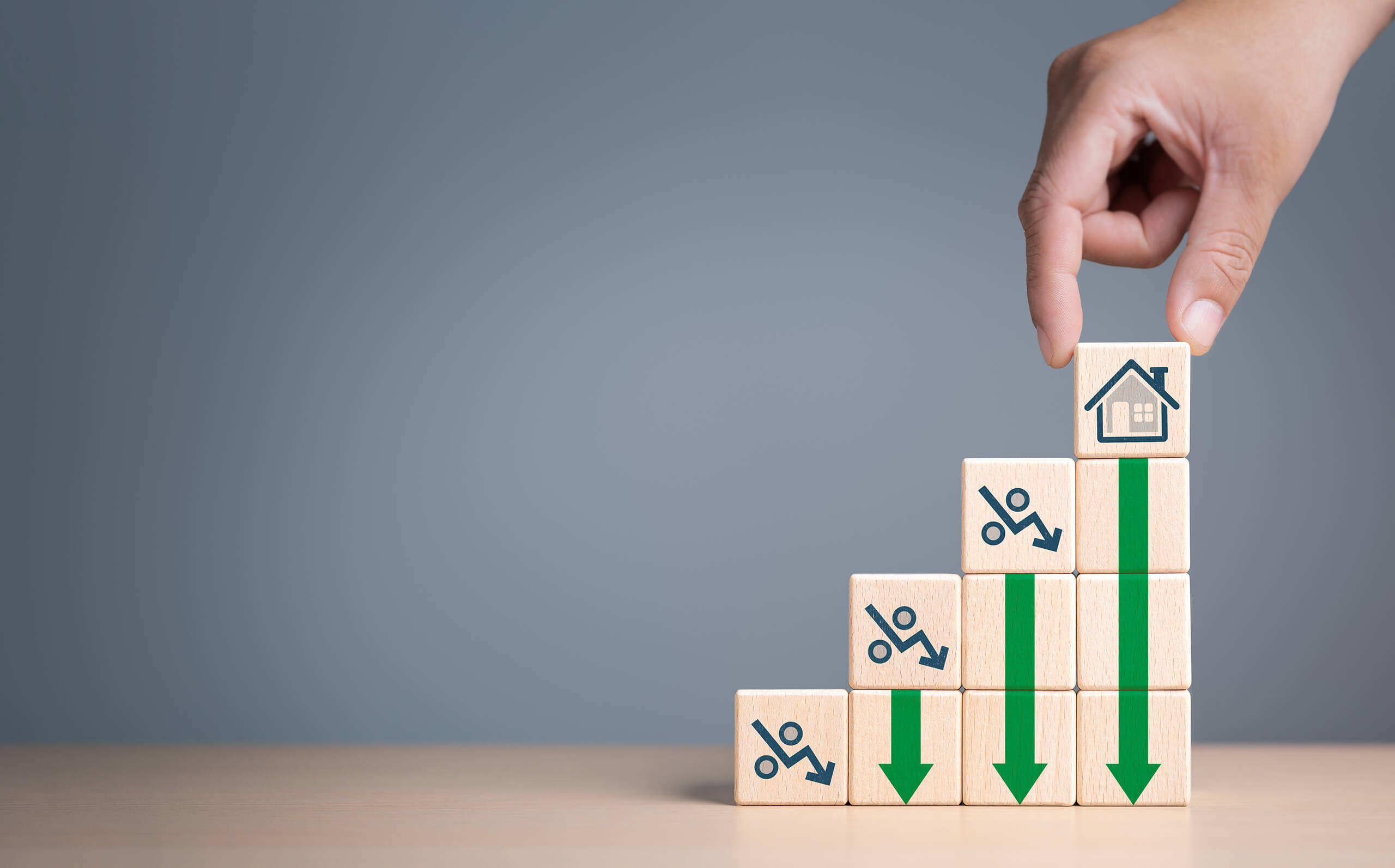 Handgestapelte Holzklötze mit Pfeilen und Haus für Immobilienpreise in Hamburg