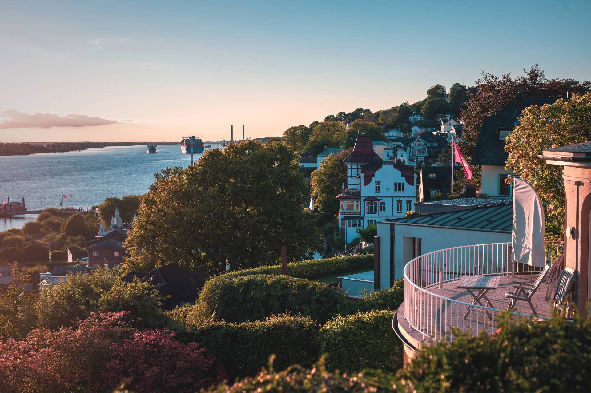 Blick über die exklusiven Villen im Hamburger Treppenviertel Blankenese auf die Elbe bei Sonnenuntergang.