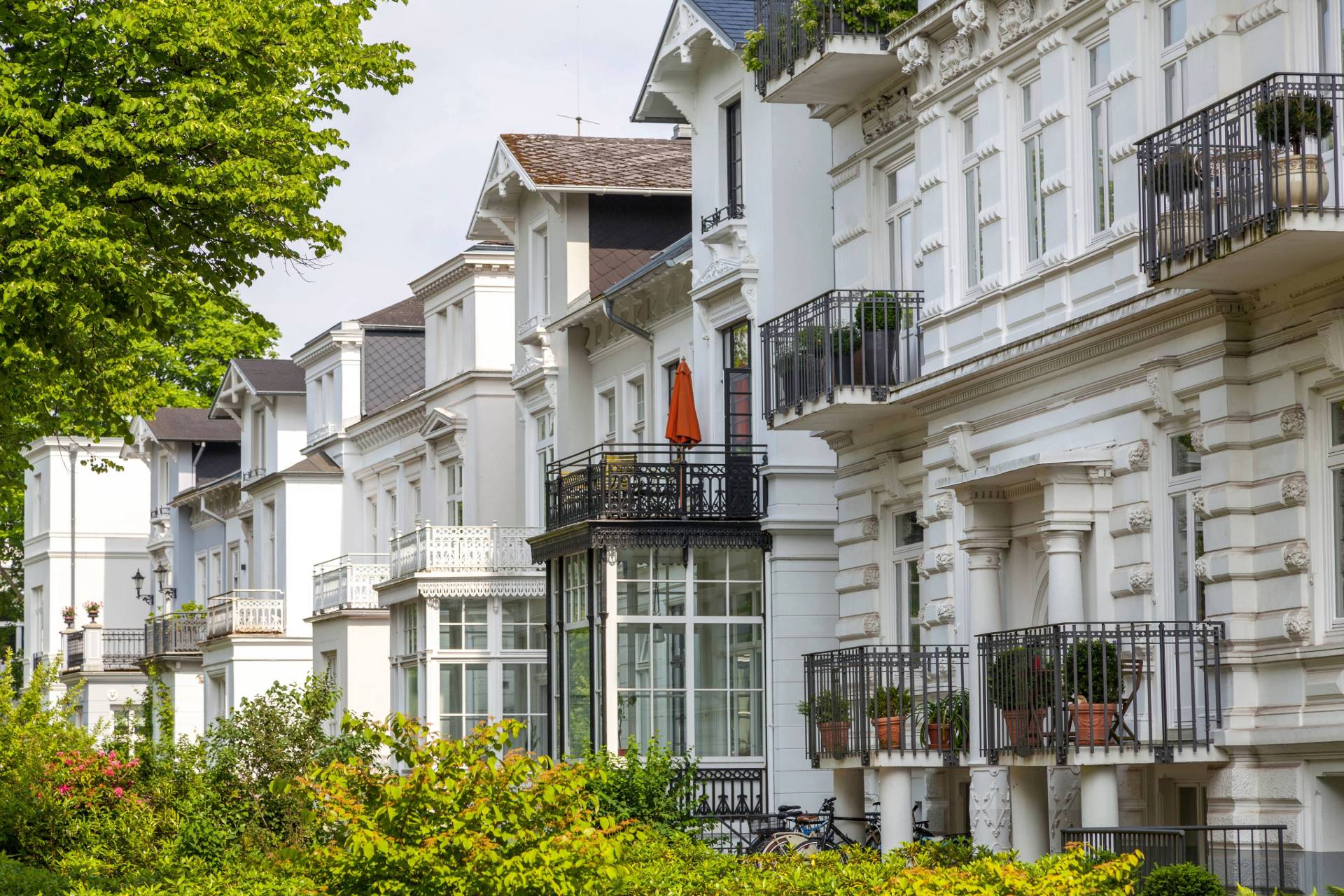 Prachtvolle weiße Stadtvillen im Jugendstil mit Balkonen und grünen Vorgärten