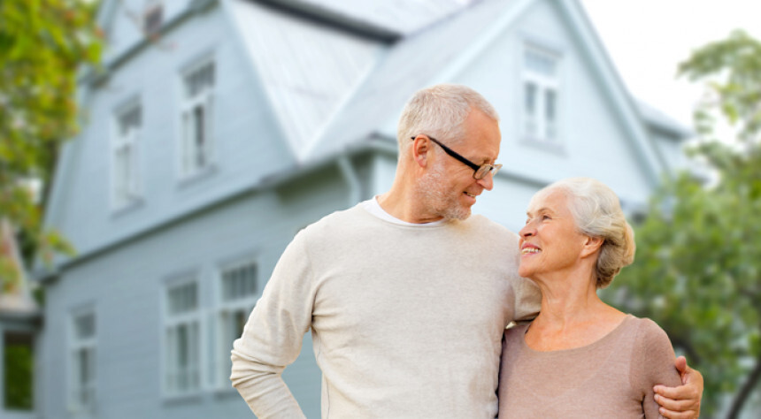 Älteres Paar sicher und komfortabel vor der eigenen Immobilie