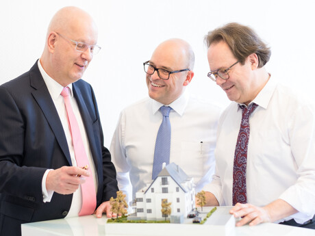 Mitarbeiter besprechen ein Bauprojekt-Modell