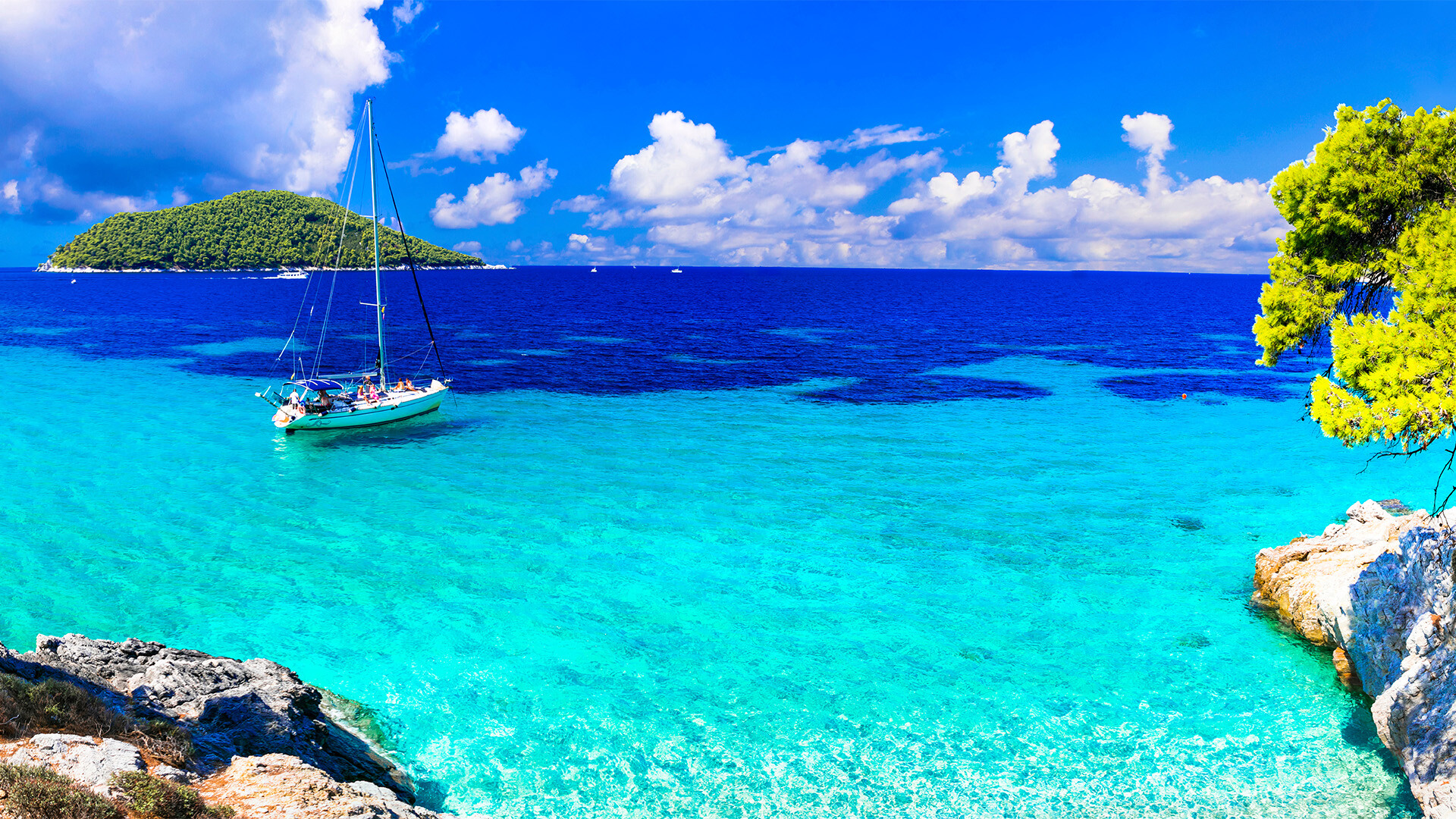 Kleine Yacht auf glasklarem Wasser zwischen griechischen Inseln