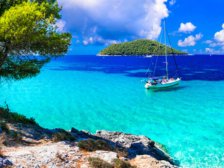 Kleine Yacht auf glasklarem Wasser zwischen griechischen Inseln