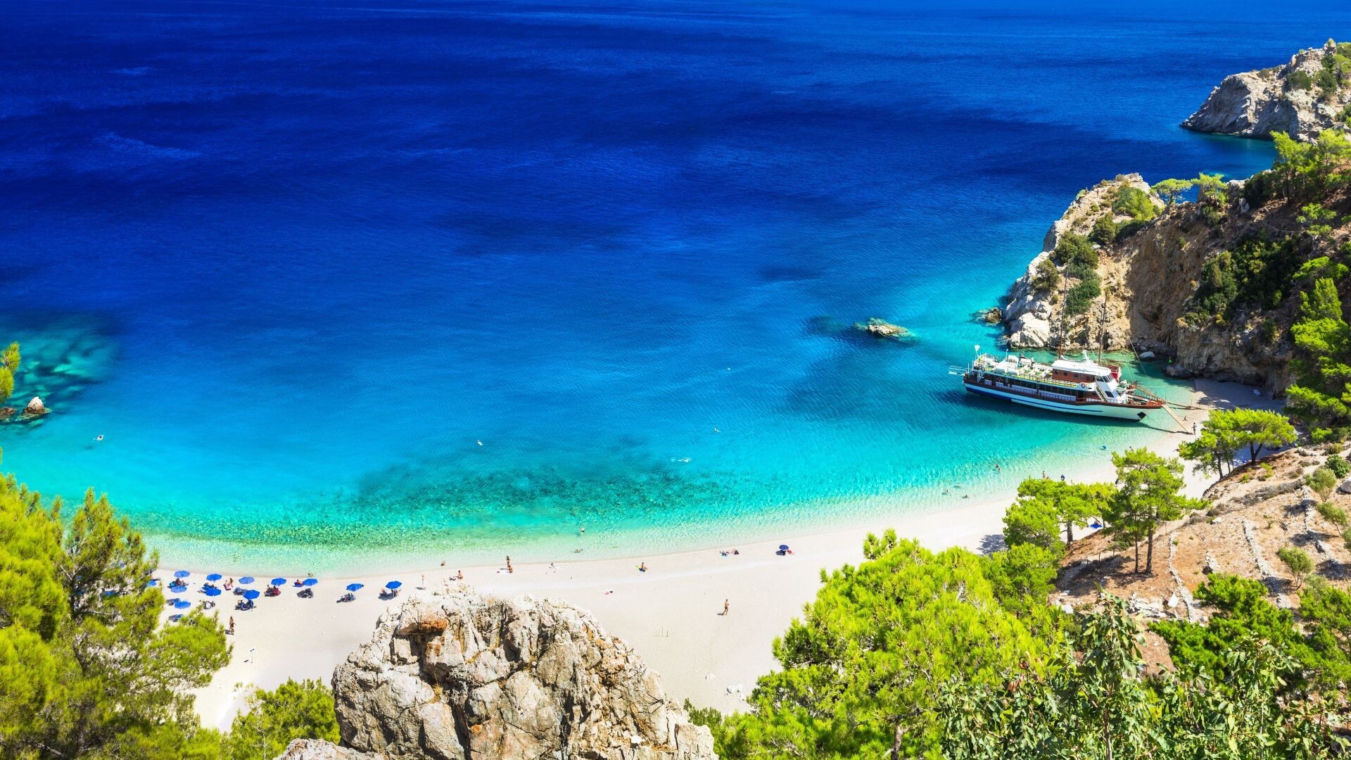 Blick auf eine Bucht einer griechischen Insel mit Sandstrand und klarem, blauen Wasser
