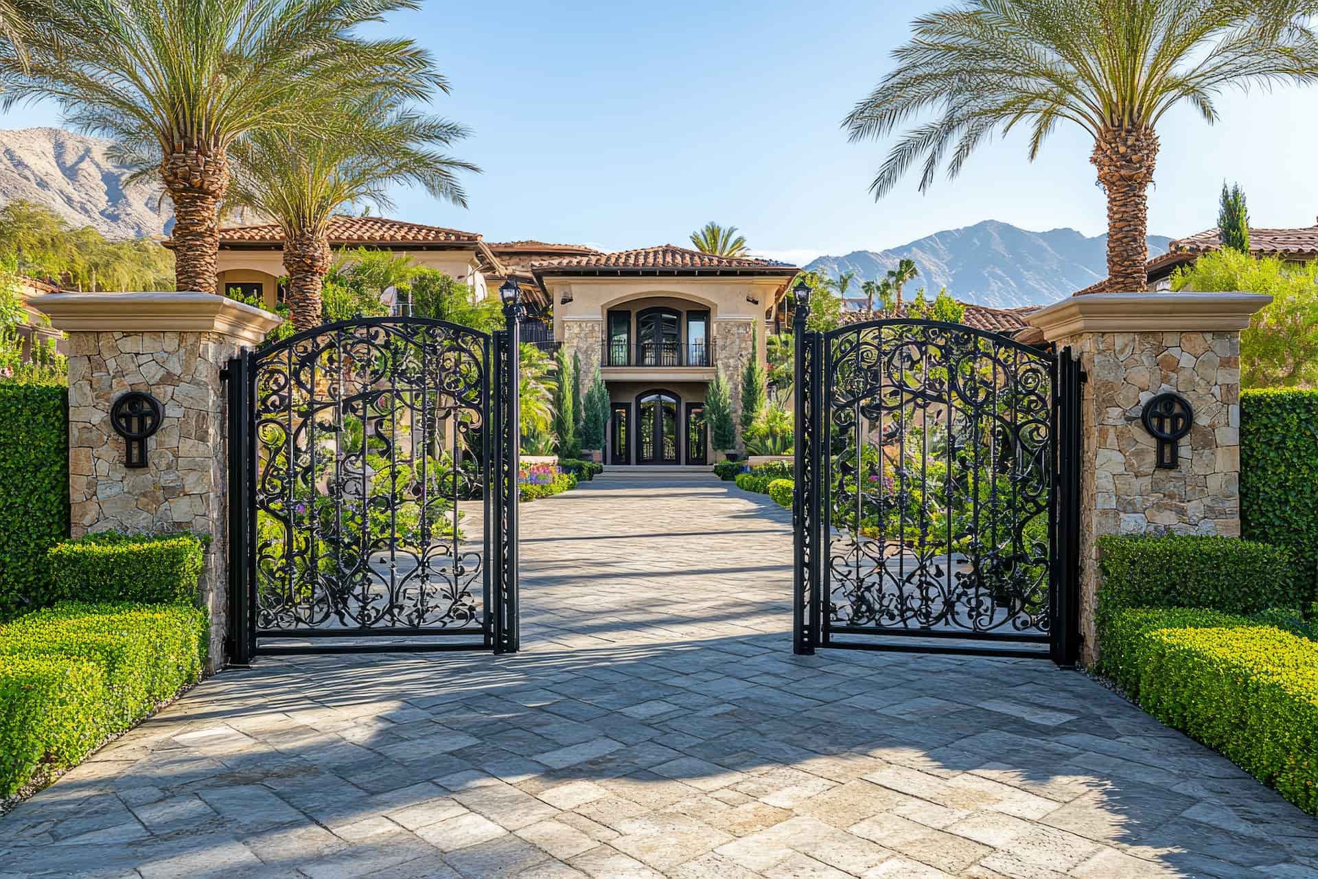 Herrenhaus mit eisernen Toren, Steinsäulen, Palmen und Bergen