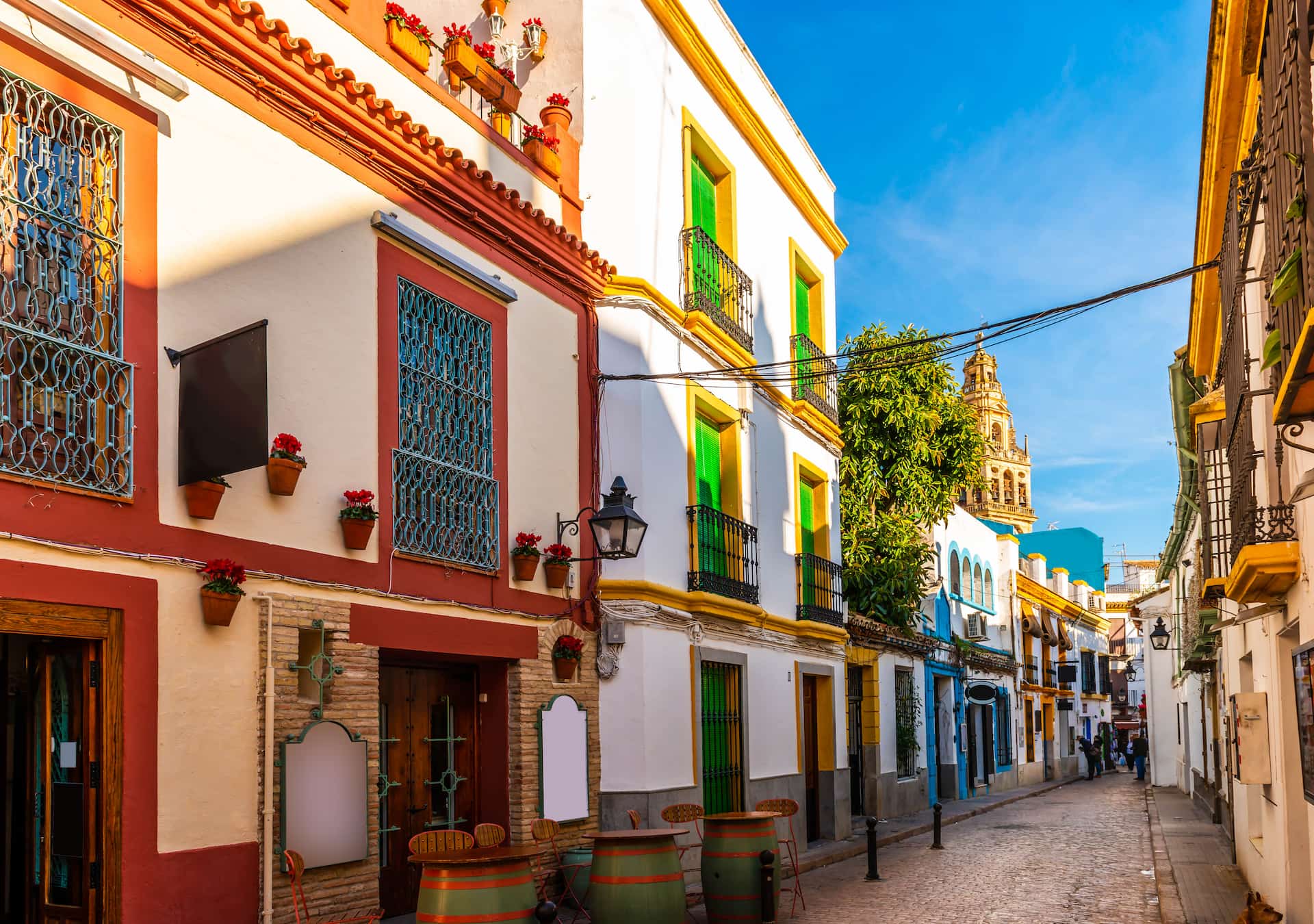 Bunte Häuser mit Blumen an einem sonnigen Kopfsteinpflasterweg