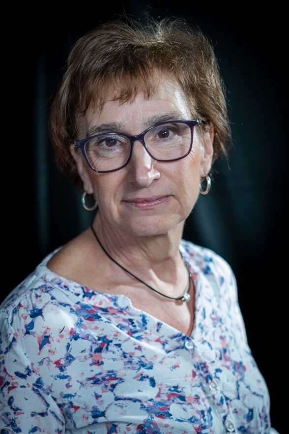 Professionelles Business-Porträt einer älteren Frau mit Brille und kurzen braunen Haaren