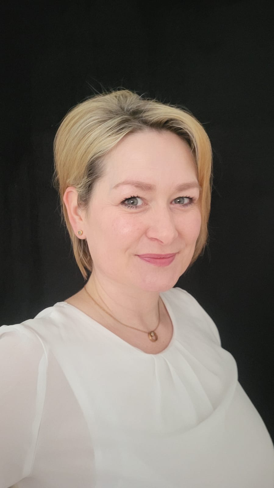 Porträt von Claudia Heger vor schwarzem Hintergrund