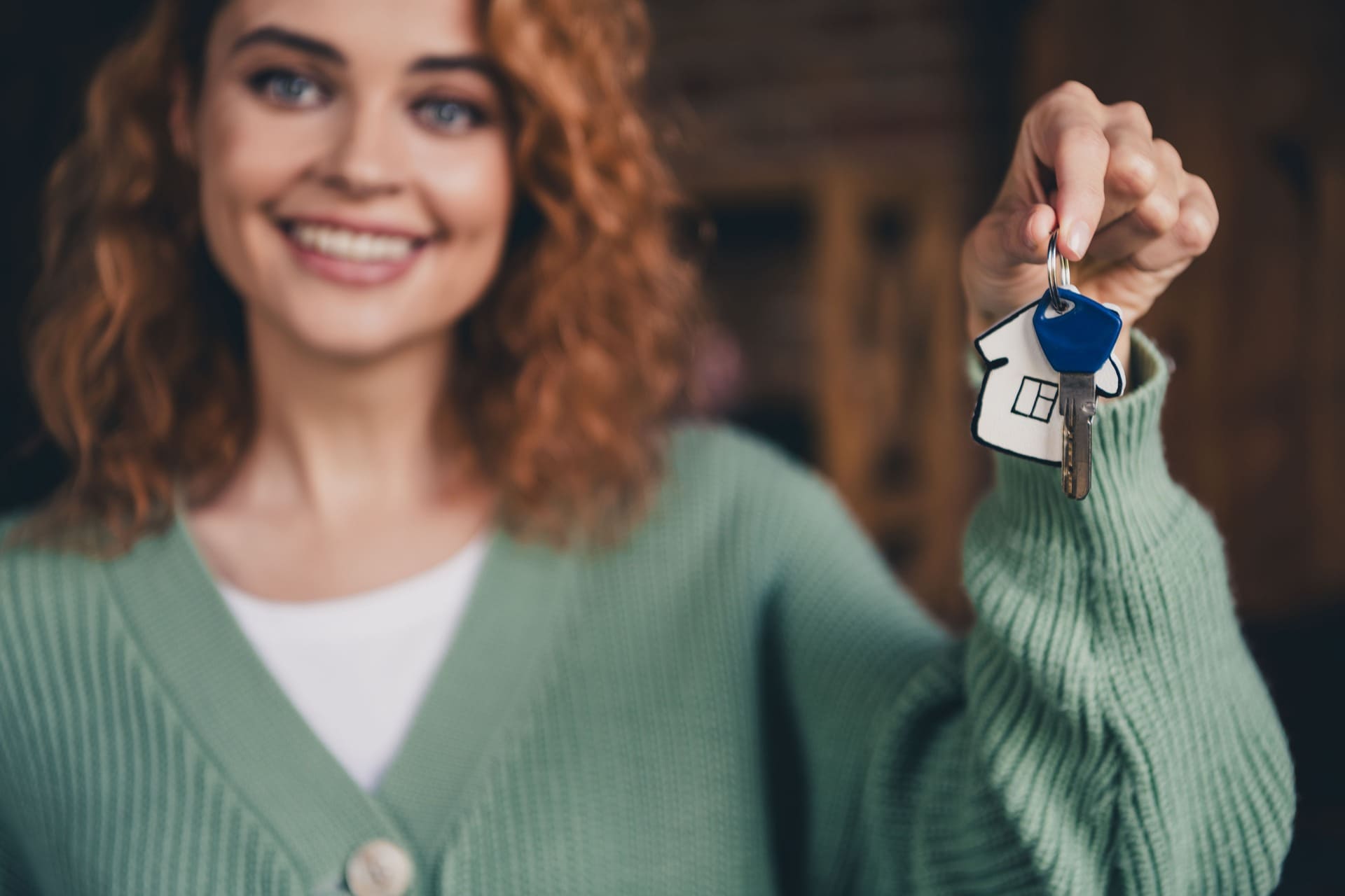 Glückliche Frau mit Hausschlüssel in der Hand
