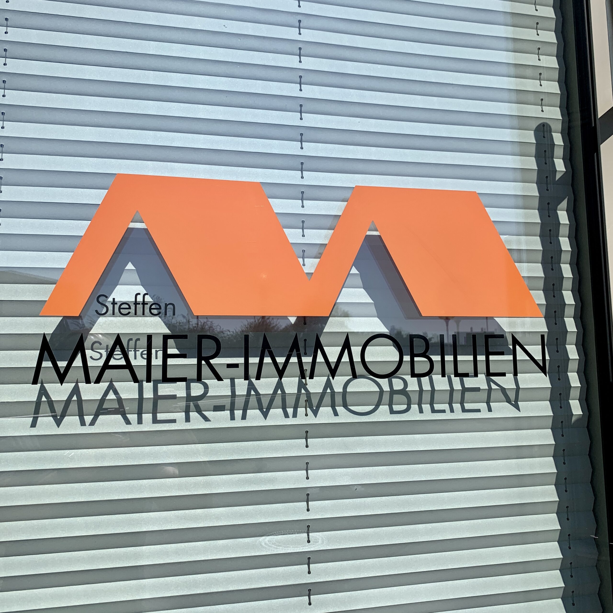 Steffen Maier Immobilien Logo auf einem Fenster
