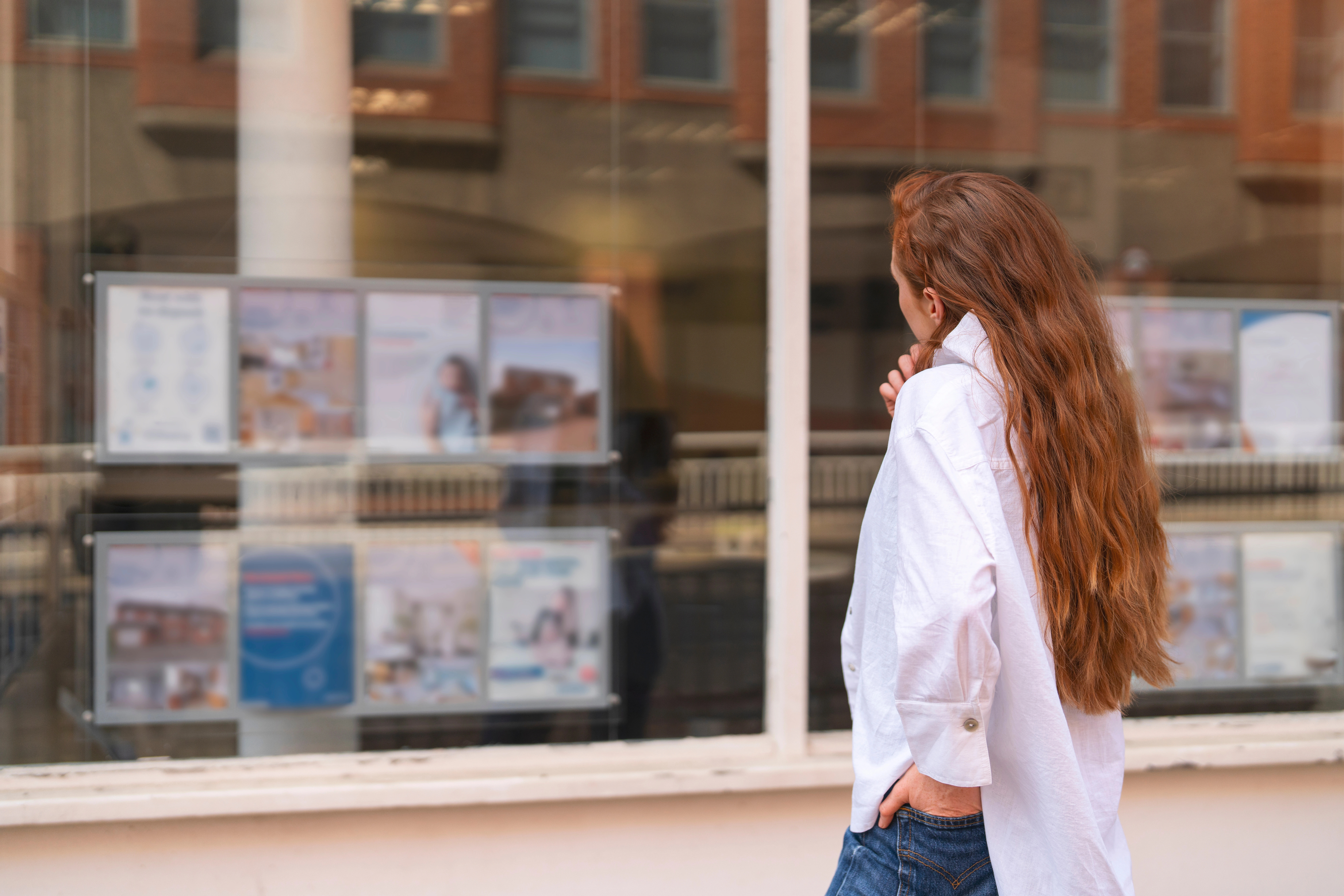 Frau betrachtet Schaufenster der Volksbank