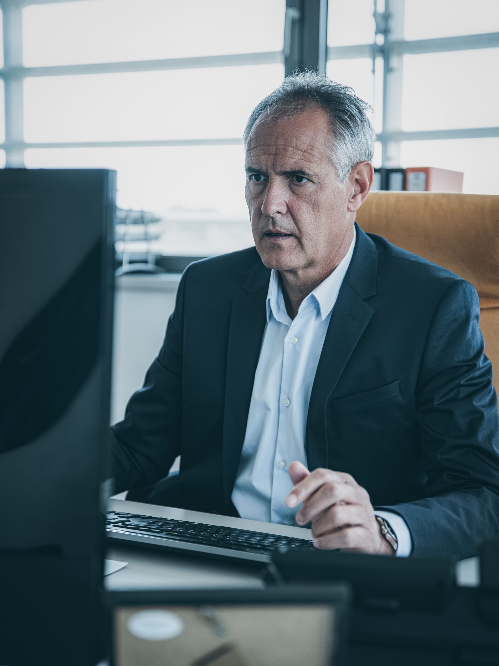 Mann im Anzug arbeitet am Computer im modernen Büro.