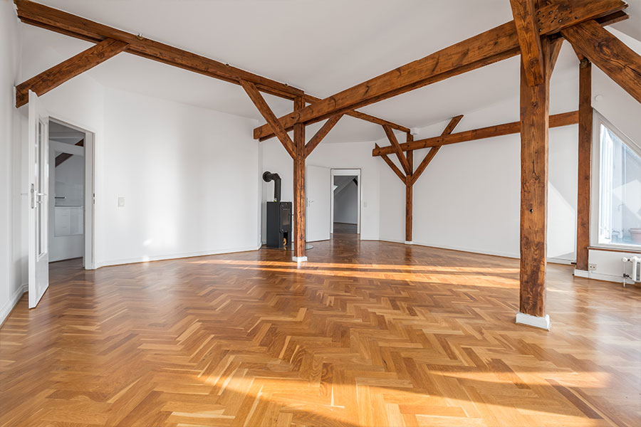 Camera con pannelli di legno, parquet, pareti color argento e grandi finestre.