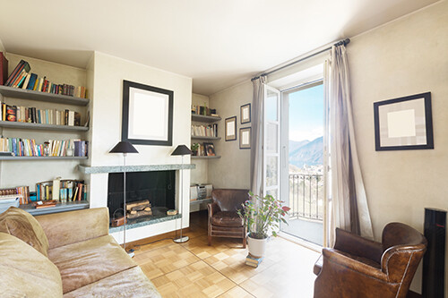 Il Wohnzimmer con Kamin, Regalen, Sitzmöbeln e Balkonblick.