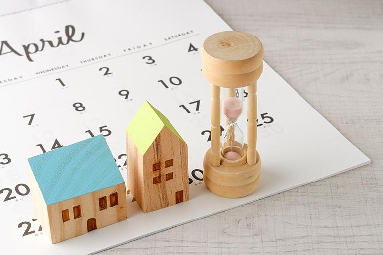 Kleines Holzhaus, Sanduhr und Kalenderblatt für April.