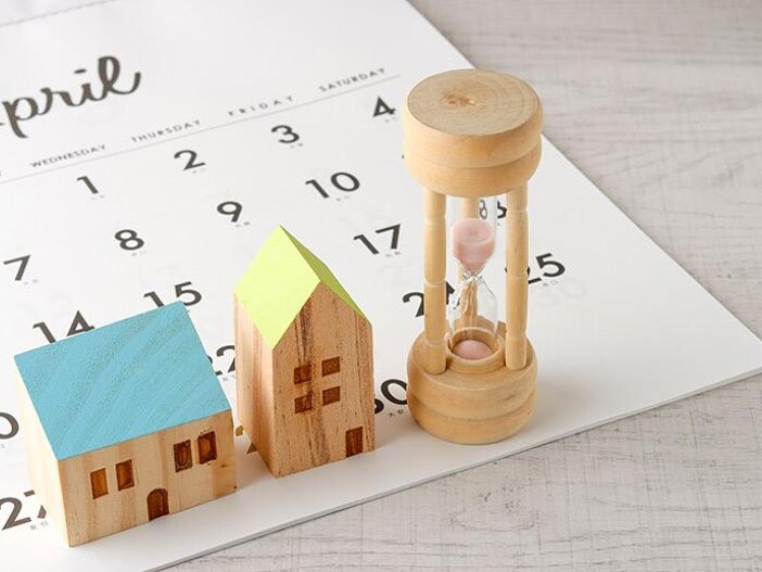Kleines Holzhaus, Sanduhr und Kalenderblatt für April.