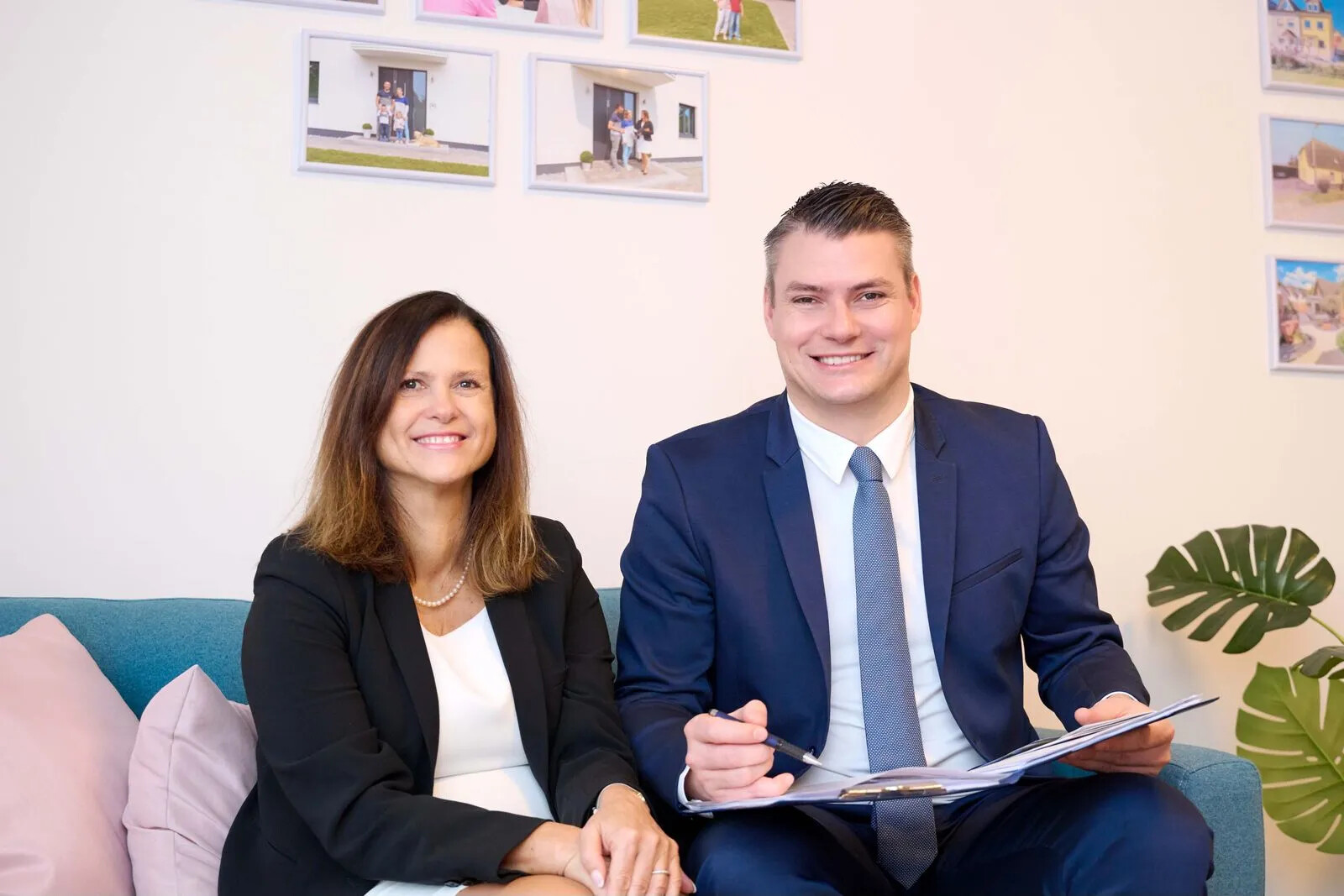 Birgit und David Kaesler mit Unterlagen auf Sofa.