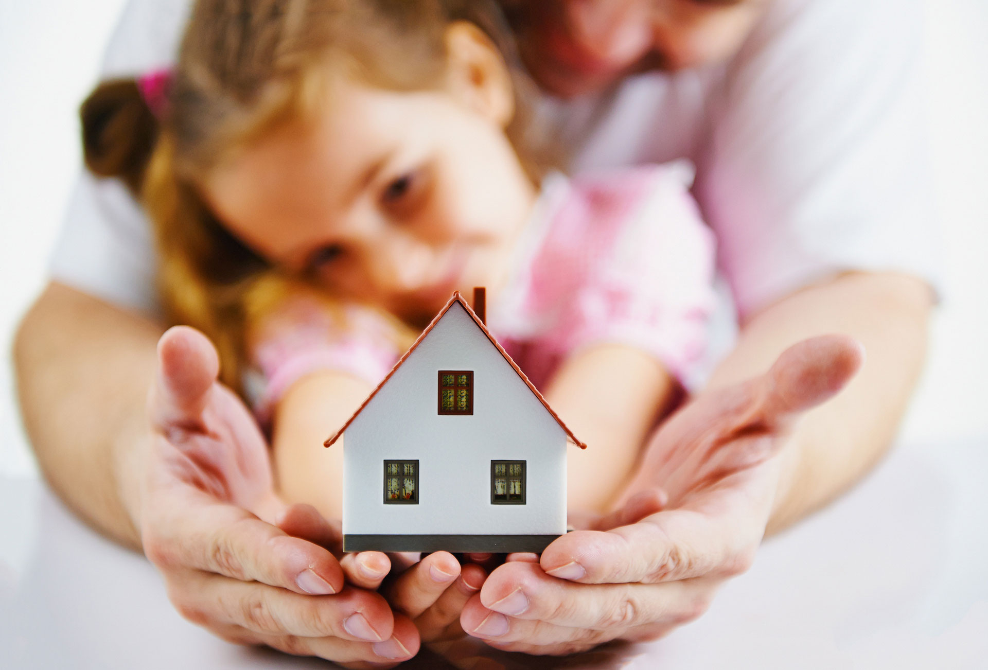 Mann und Tochter halten Modellhaus in Händen