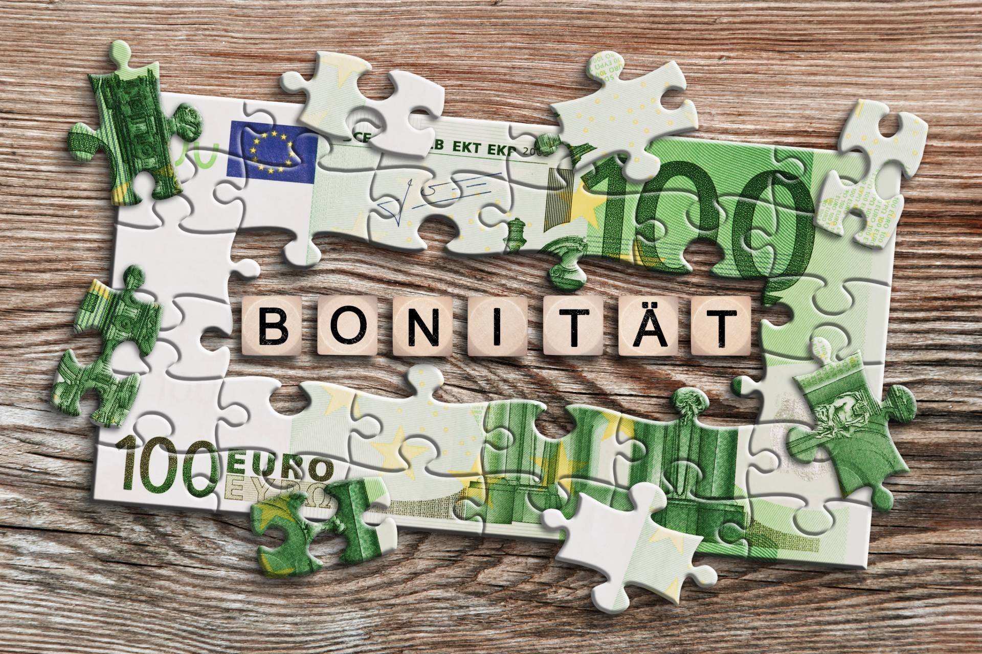 Puzzle aus einem 100-Euro-Schein mit dem Wort Bonität.