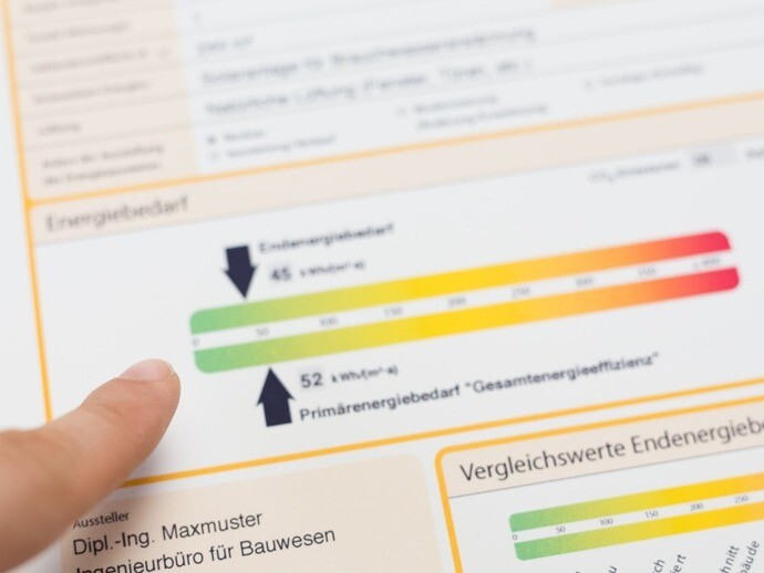 Jemand deutet mit seinem Finger auf einen Energieausweis