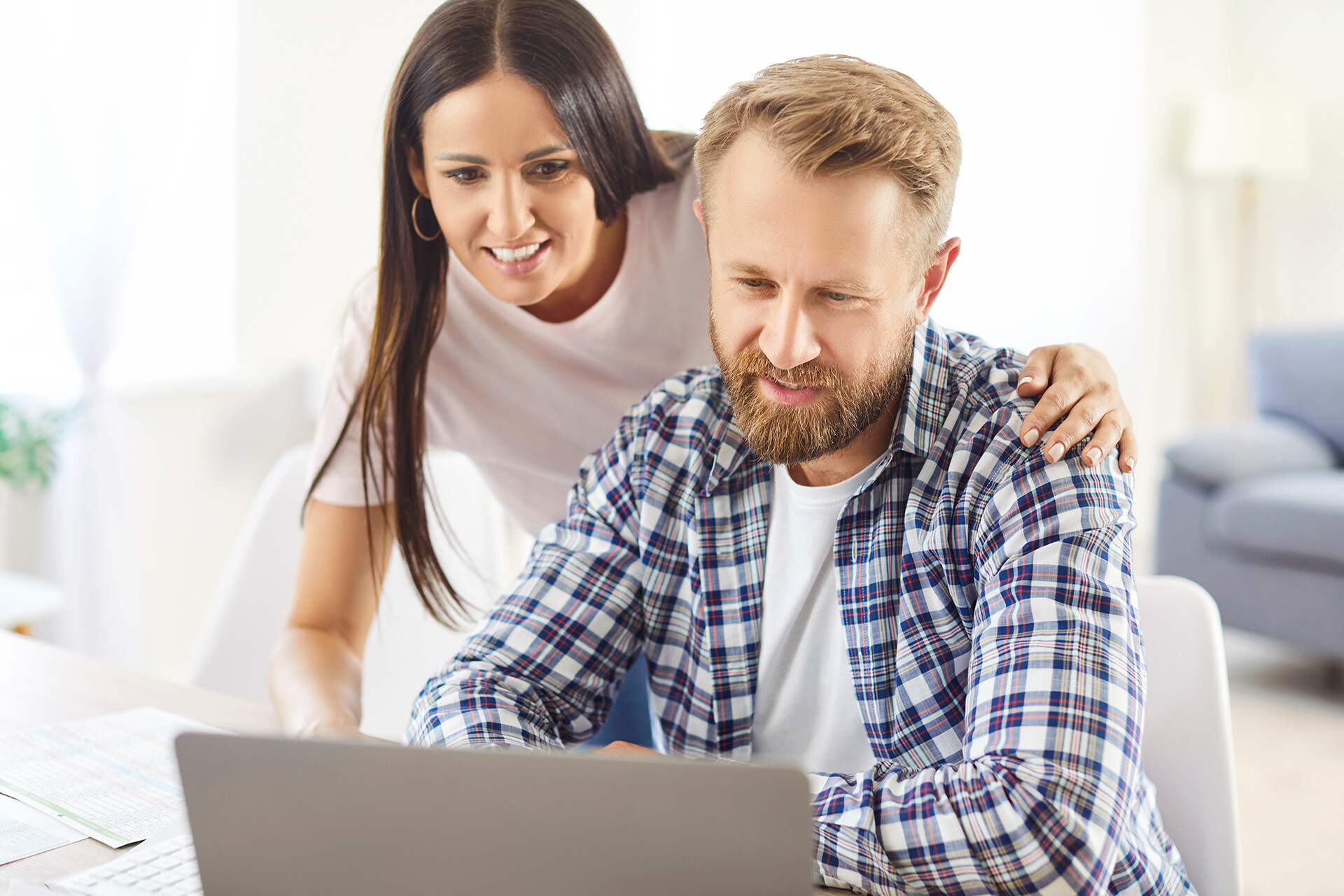 Paar sitzt zu Hause gemeinsam am Laptop.