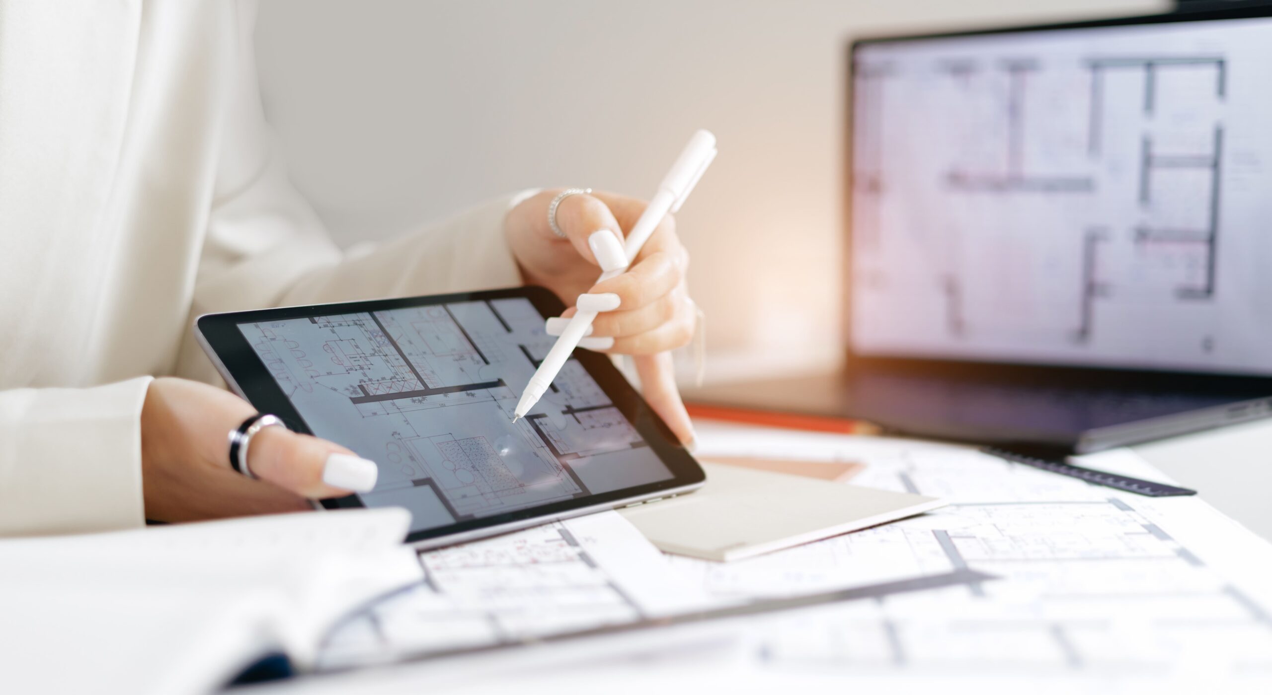 Maklerin erklärt Grundriss auf Tablet