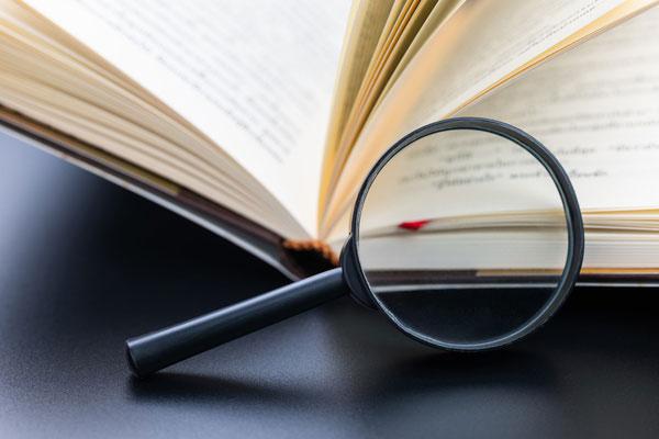 Lupe zeigt auf Buch.