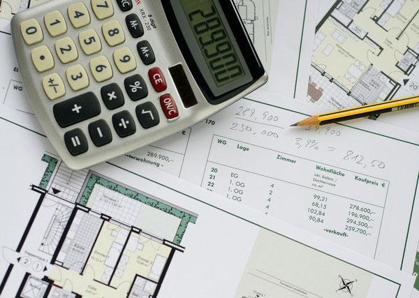 Taschenrechner liegt auf Immobilienunterlagen.