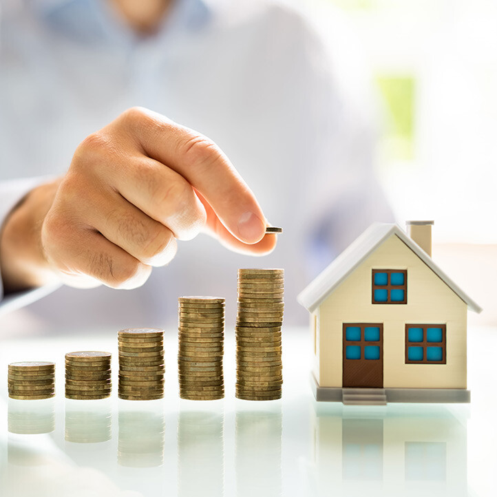 Münzstapel mit Modellhaus