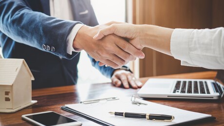 Makler und Kunde geben sich einen Handschlag